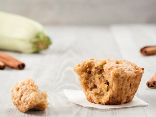 Close up view of muffin with zucchini, carrots, apple and cinnamon on gray wooden background. Sweet vegetables homemade muffins. Toddler-friendly recipe idea. Copy space. Shallow DOF