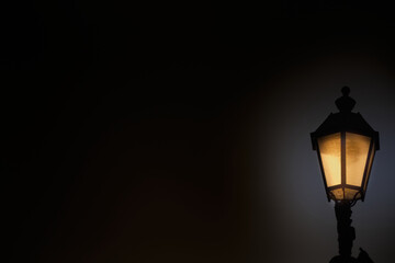 An old glowing gas lantern against the night sky