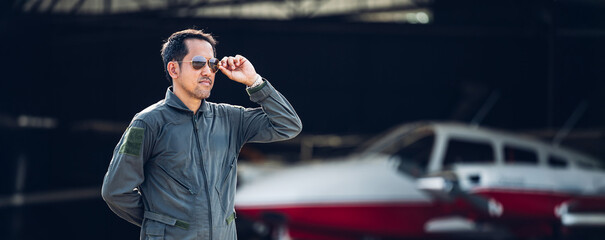 Pilot in uniform at airport. Asian Confident male pilot in uniform  and checking flight plan © kanpisut