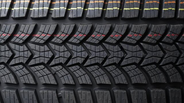 New winter tire rotation close-up, highlighting tread pattern for enhanced grip and safety on icy roads. Perfect for automotive maintenance, winter driving, and safety concepts.