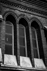 Urban architecture, ancient arched windows, brownstone and eaves of a building with a cracked...