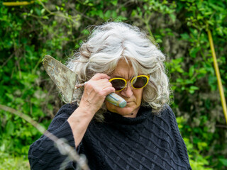 Senior woman holding trowel taking break from gardening