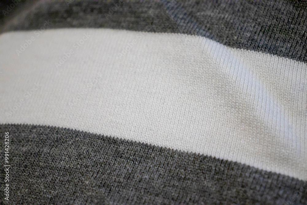 Poster close-up of a textured fabric with gray and white stripes, showcasing its softness and intricate kni