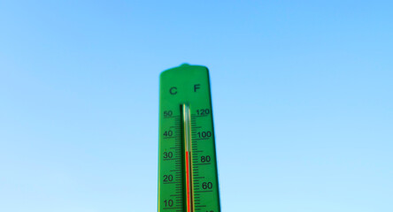 Thermometer for measuring outdoor air temperature. Meteorological device for observing and measuring the weather. Weather forecast. Thermometer on blue sky background. Hot weather, drought in summer.