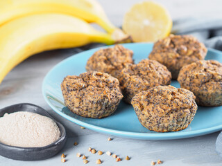 Close-up view of healthy gluten-free homemmade banana muffins with buckwheat flour. Vegan muffins with poppy seeds on blue plate over gray wooden table. Copy space