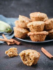 Close up view of muffin with zucchini, carrots, apple and cinnamon on black cement background. Sweet vegetables homemade muffins. Toddler-friendly recipe idea. Copy space. Shallow DOF