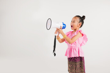Portrait Thailand kid girl smiling traditional Thai dress costume shouting by megaphone, studio...