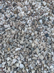 Background of natural gray small pebbles or stone in a garden paths and flower beds.
