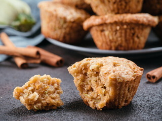 Close up view of muffin with zucchini, carrots, apple and cinnamon on black cement background. Sweet vegetables homemade muffins. Toddler-friendly recipe idea. Copy space. Shallow DOF