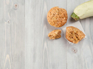 Top view of muffin with zucchini, carrots, apple and cinnamon on gray wooden background. Sweet vegetables homemade muffins. Toddler-friendly recipe idea. Copy space. Shallow DOF