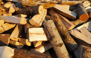 Firewood background, texture. Chopped firewood close up. Chopping wood and cutting timber. Preparation of firewood in village for heating the house in winter. A pile of firewood close-up.