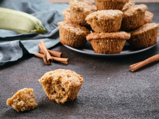Close up view of muffin with zucchini, carrots, apple and cinnamon on black cement background. Sweet vegetables homemade muffins. Toddler-friendly recipe idea. Copy space. Shallow DOF