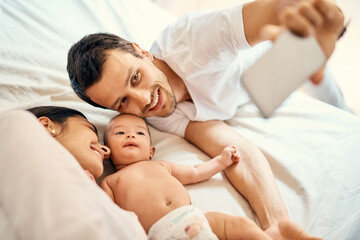 Mom, dad and baby on bed for selfie with smile, love and family in home for happy memory. Photography, parents and newborn infant in bedroom with support for growth, development or bonding in morning