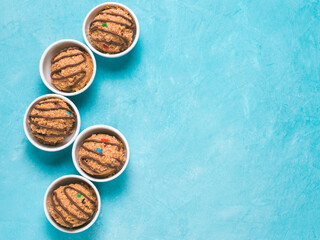 Safe-to-eat raw monster cookie dough in small portion bowl on blue background. Ideas and recipes for kids and toddlers meal. Top view or flat-lay. Copy space for text. © fascinadora