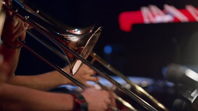 Close-up of brass musicians playing trombones in a classical orchestra event.
