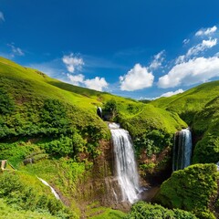 Obraz premium A breathtaking view of a lush hillside showcasing a cascading waterfall under a bright blue sky sprinkled with light, fluffy clouds