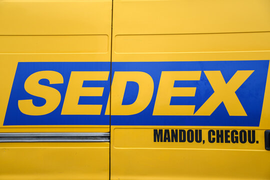 Yellow "Correios" van. Sedex and Correios logo on the car. Correios post office of Brazil logistics warehouse. Mail delivery car parked. 