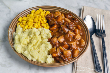   beef stew with  mashed potatoes and corn,