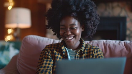 A person sitting on a couch with a laptop, possibly working or browsing online