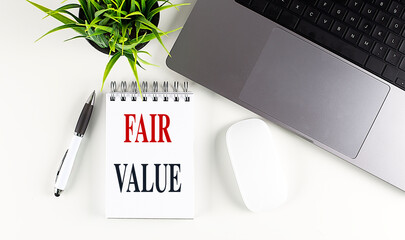 Fair value assessment with notepad, laptop, and office supplies on desk