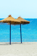 Two beach umbrellas are on the beach