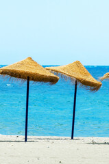 Two beach umbrellas are on the beach