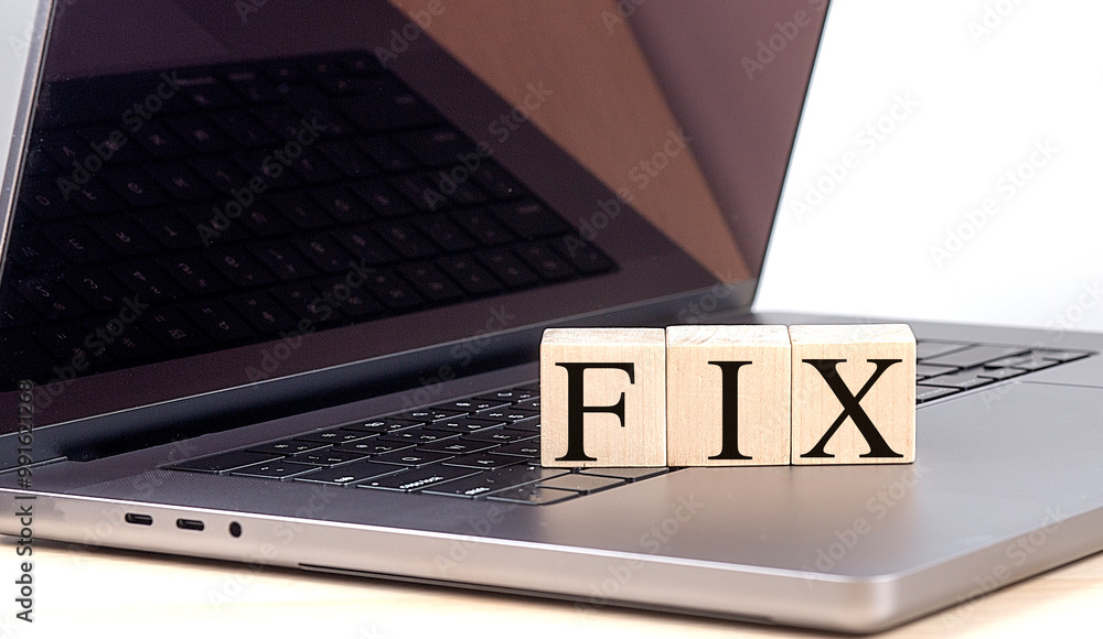 Poster fix text on wooden blocks placed on a laptop keyboard