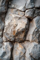 A detailed close-up of grey rocks with visible natural cracks, highlighting the textures and geological formations.