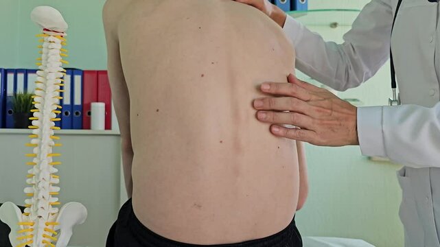 Surgeon examines spine and posture scoliosis and spinal deformities in a teenager