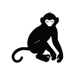 Obraz premium a black silhouette of a monkey. The monkey is sitting on its hind legs with its front paws on the ground and its tail curled around its body