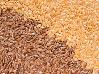 Golden and brown flax seed as background. Top view or flat lay