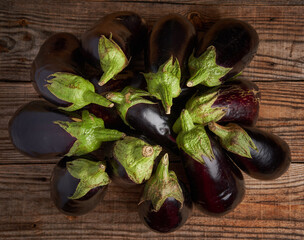 Raw organic eggplants on a wooden board