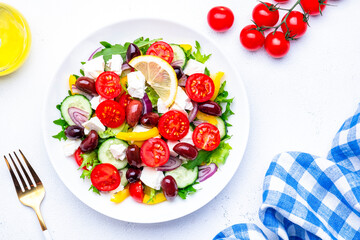 Greek salad with vegetables, cheese and lettuce, white background, top view