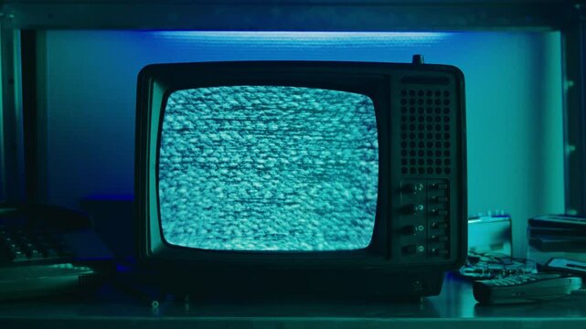 Retro TV, vintage television In a nostalgic setup, a retro TV displays grain on screen, scary halloween night device good for chroma key and green screen.