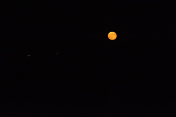 glowing red moon shining against a dark night sky