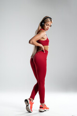 Sexy fitness woman. Beautiful athletic girl, isolated on the gray background