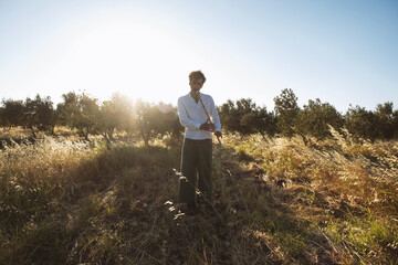 Portrait of a man playing ney flute in an olive field