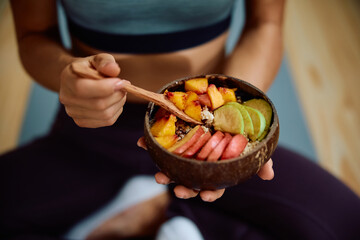 Close up of athlete eating healthy food after her sports training.