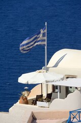 Obraz premium Bandera griega en Oia, isla de Santorini, Grecia