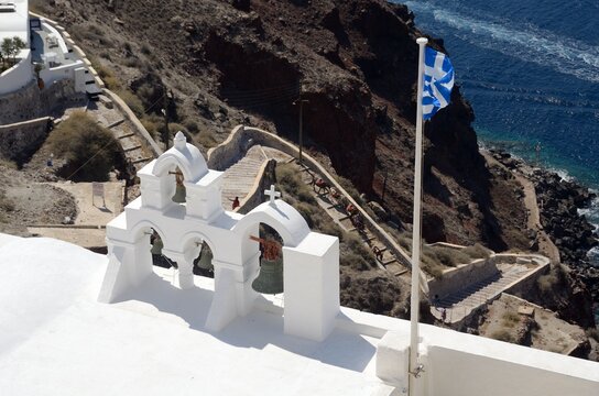 Campanario y bandera en Oia, isla de Santorini, Grecia