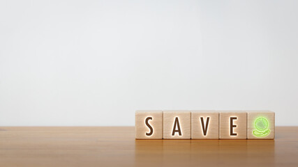 A wooden block with the word save written and globe icon on it. Concept of sustainable and environmental saving.