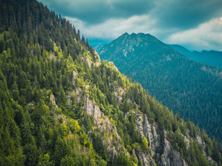 Stunning aerial shot of Romania&rsquo;s Transfagarasan road nestled in green, misty mountains.