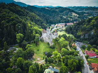 Stunning drone shot of Bran Castle, highlighting its unique architecture against a backdrop of the Carpathian Mountains.