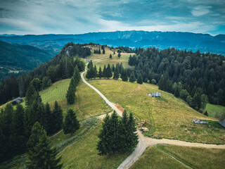  Aerial view of a panoramic landscape with green meadows and mountains on the horizon, showcasing nature's beauty.