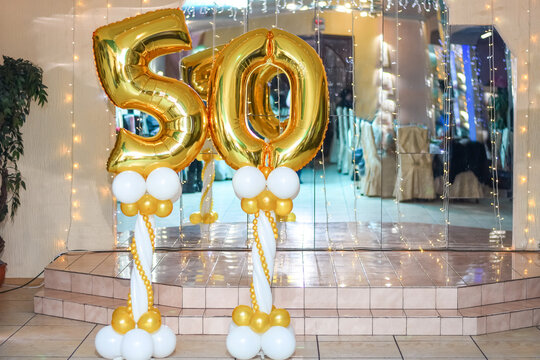 The golden foil balloon number is fifty. a postcard for the 50th anniversary. birthday, celebration. the banner