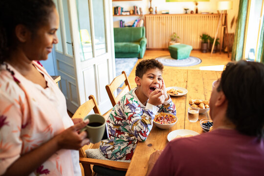 Family breakfast time with kids and parents at kitchen table