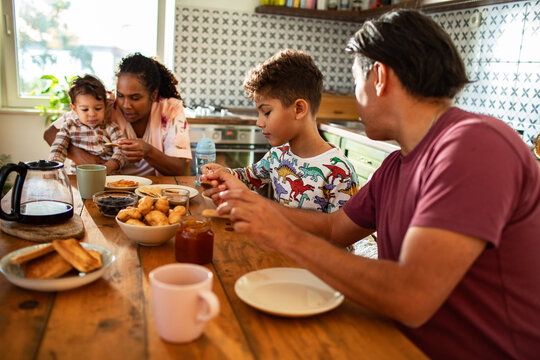 Family breakfast time with kids and parents at kitchen table