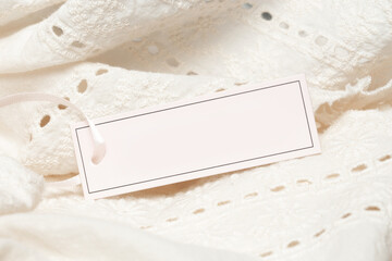 Close up of price tag of clothing item. Blank label tag mockup on clothes. Fashion industry and retail concept.