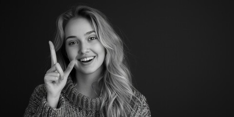 Fototapeta premium A black and white photograph of a woman forming a peace sign with her hand