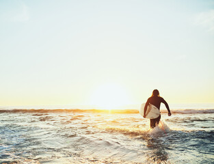 Running, surfer and man with surfboard at beach for water sport, adventure and tropical vacation. Back, tourist and person for surfing at ocean with fitness, mockup and activity for hobby and sunset